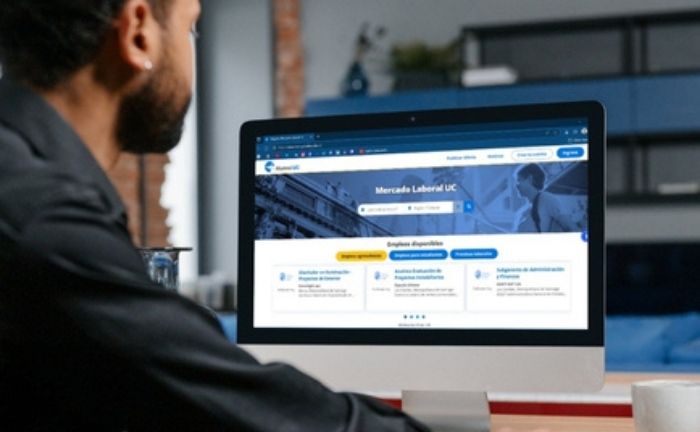 Fotografía de una persona frente a la pantalla de un computador de escritorio, visualizando el sitio web mercadolaboraluc.cl