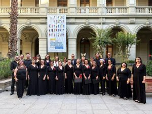 Fotografía del Coro Alumni UC en el patio de la virgen de la Casa Central junto al Rector Ignacio Sánchez
