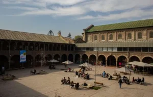 Fotografía de uno de los patios del Campus Oriente UC visto se ven mesas y personas