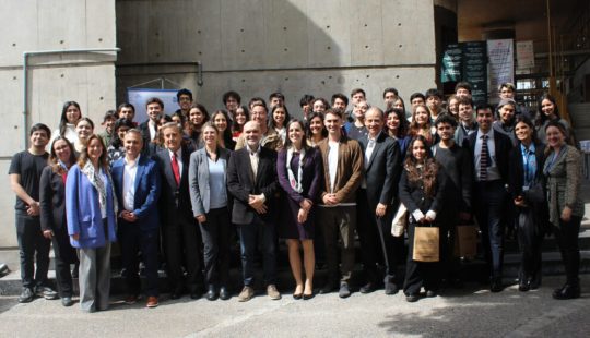 Fotografía de un gran grupo de Alumni UC que viven alrededor del mundo junto a autoridades UC