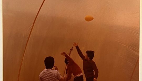 Fotografía de archivo de cuatro personas jugando con un globo