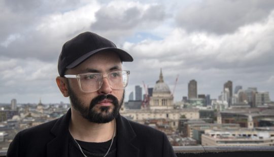 Fotografía de Tomás Brantmayer viendo al horizonte con una ciudad de fondo