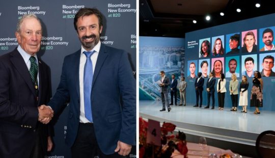 Gráfica del alumni UC, Gonzalo Vial, estrechando la mano de otro hombre tras reconocimiento de Bloomberg New Economy Catalysts