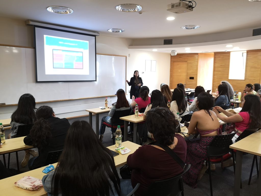 Una persona presentando un Power Point a grupo de personas en una sala de clases