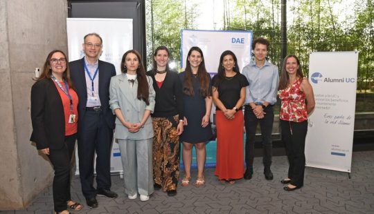 Fotografía de un grupo de personas de pie vestidas semi formal