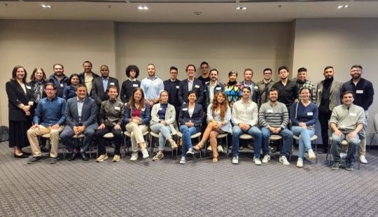 Fotografía de un grupo de 30 personas en dos filas, una sentados, sonriendo formalmente