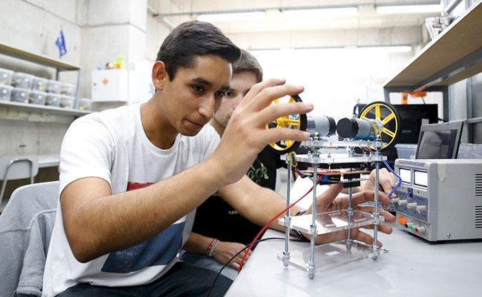 Fotografía de dos personas jóvenes haciendo un experimento de ingeniería