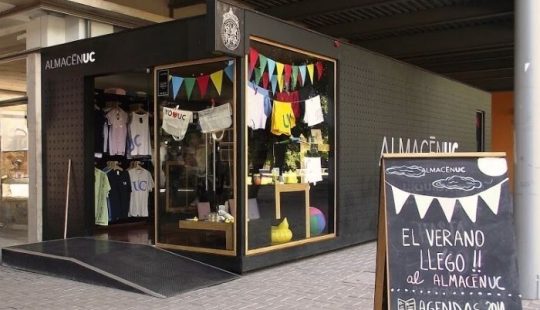 Fotografía del frontis del Almacén UC sucursal Campus San Joaquín. Se ve además un cartel que dice "Almacén UC. El verano llegó al almacén UC"