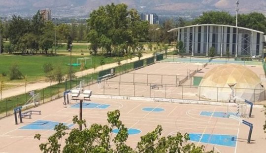 Fotografía de las canchas de básquetbol y ténis del Campus San Joaquín, se ve además la parte trasera del Gimnasio