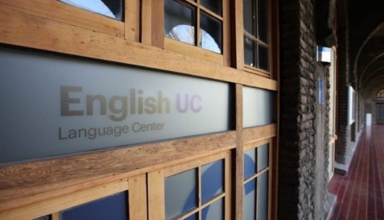 Fotografía de el logo de English UC impreso en una pared