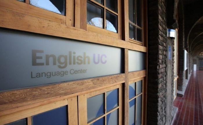 Fotografía de el logo de English UC impreso en una ventana.