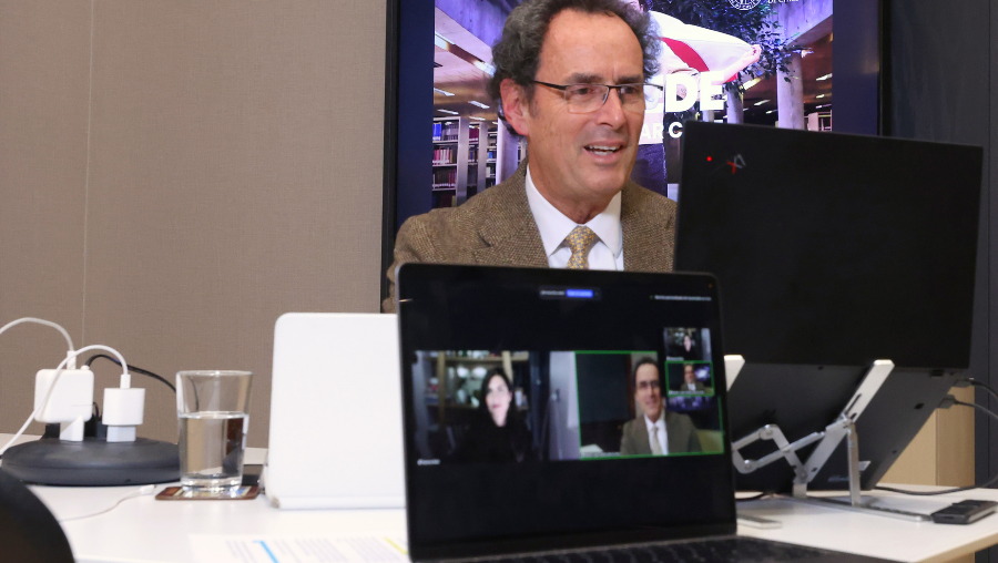 Fotografía del rector Juan Carlos de la Llera frente a un computador hablando