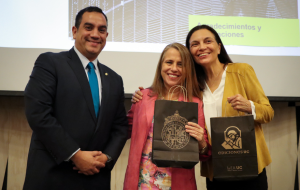 Fotografía de tres personas, dos de ellas sosteniendo regalos