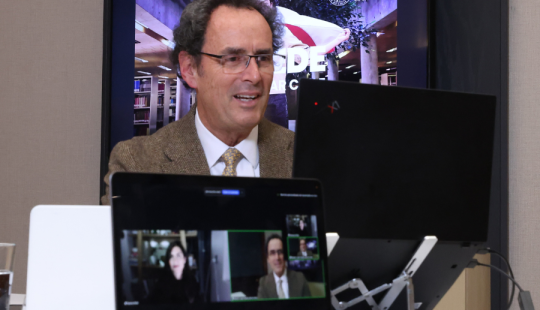 Fotografía del rector Juan Carlos de la Llera frente a un computador hablando