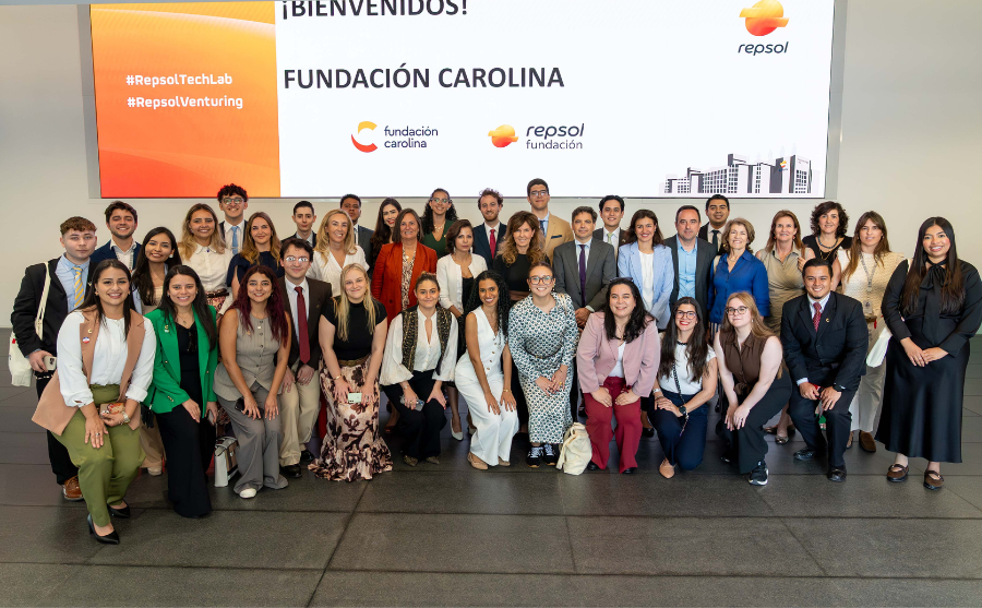 Fotografía de decenas de personas vestidas semi formal, de fondo se ve en grande el nombre Fundación Carolina