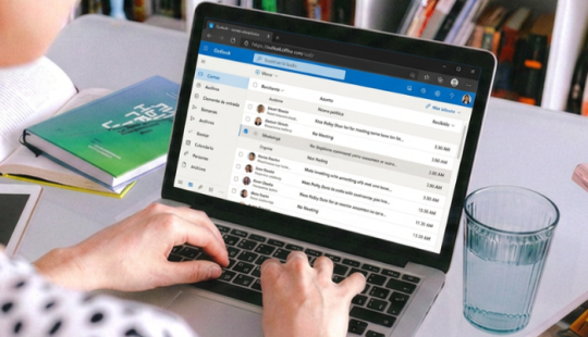 Fotografía de una persona en un computador en su mail Outlook