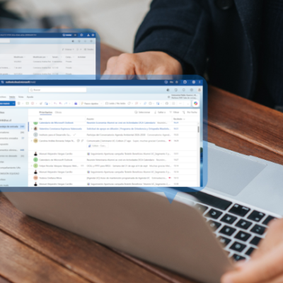 Fotografía de una persona con su computador y unas burbujas sobresaliendo con un correo abierto
