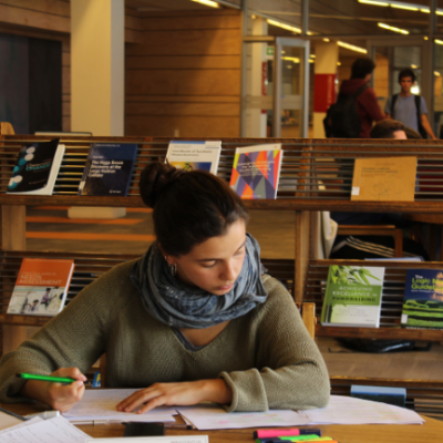 Fotografía de una persona estudiando en una biblioteca