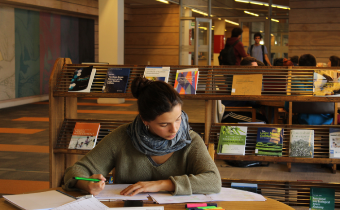 Fotografía de una persona estudiando en una biblioteca